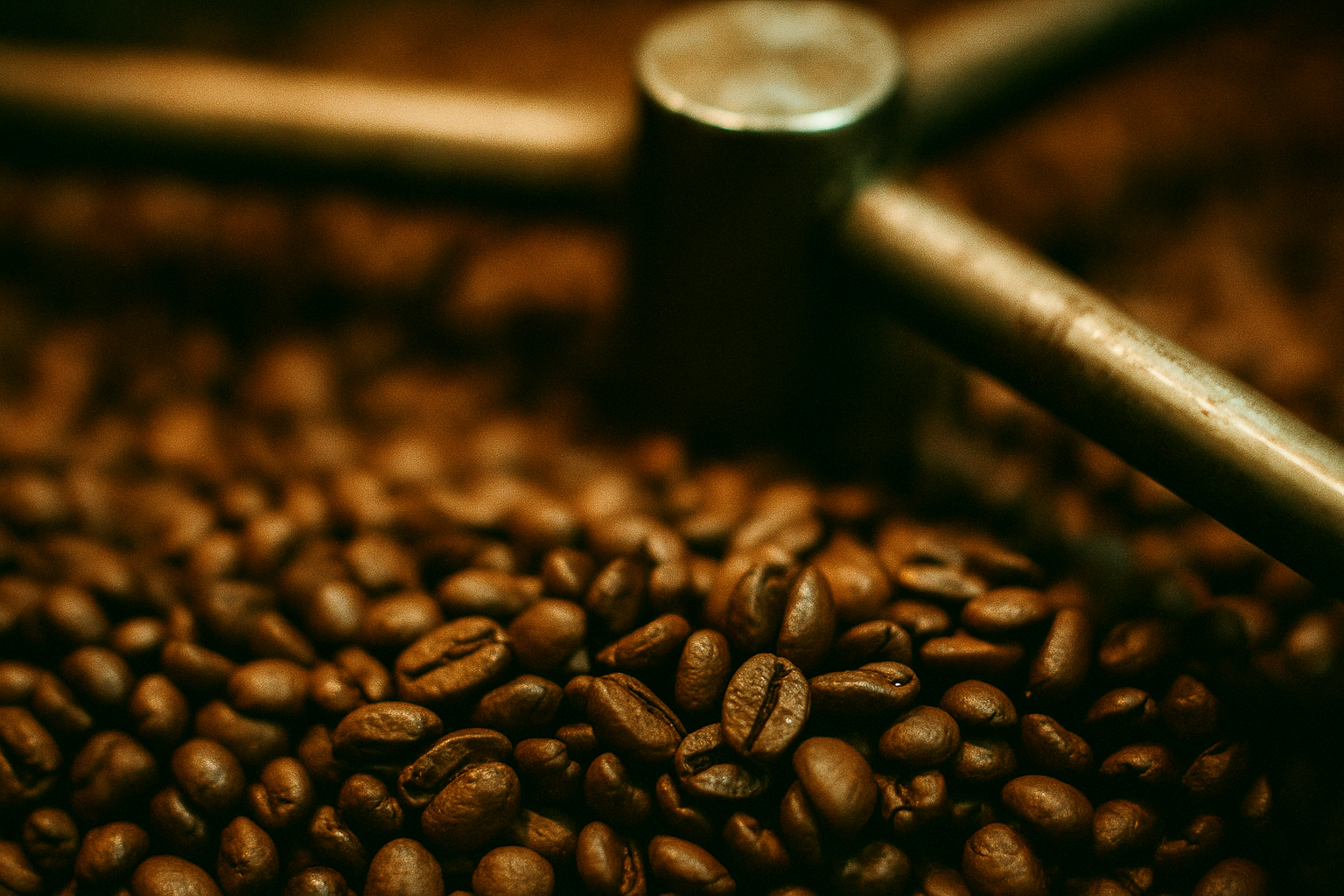 Roasted coffee beans with a metal grinder in the background